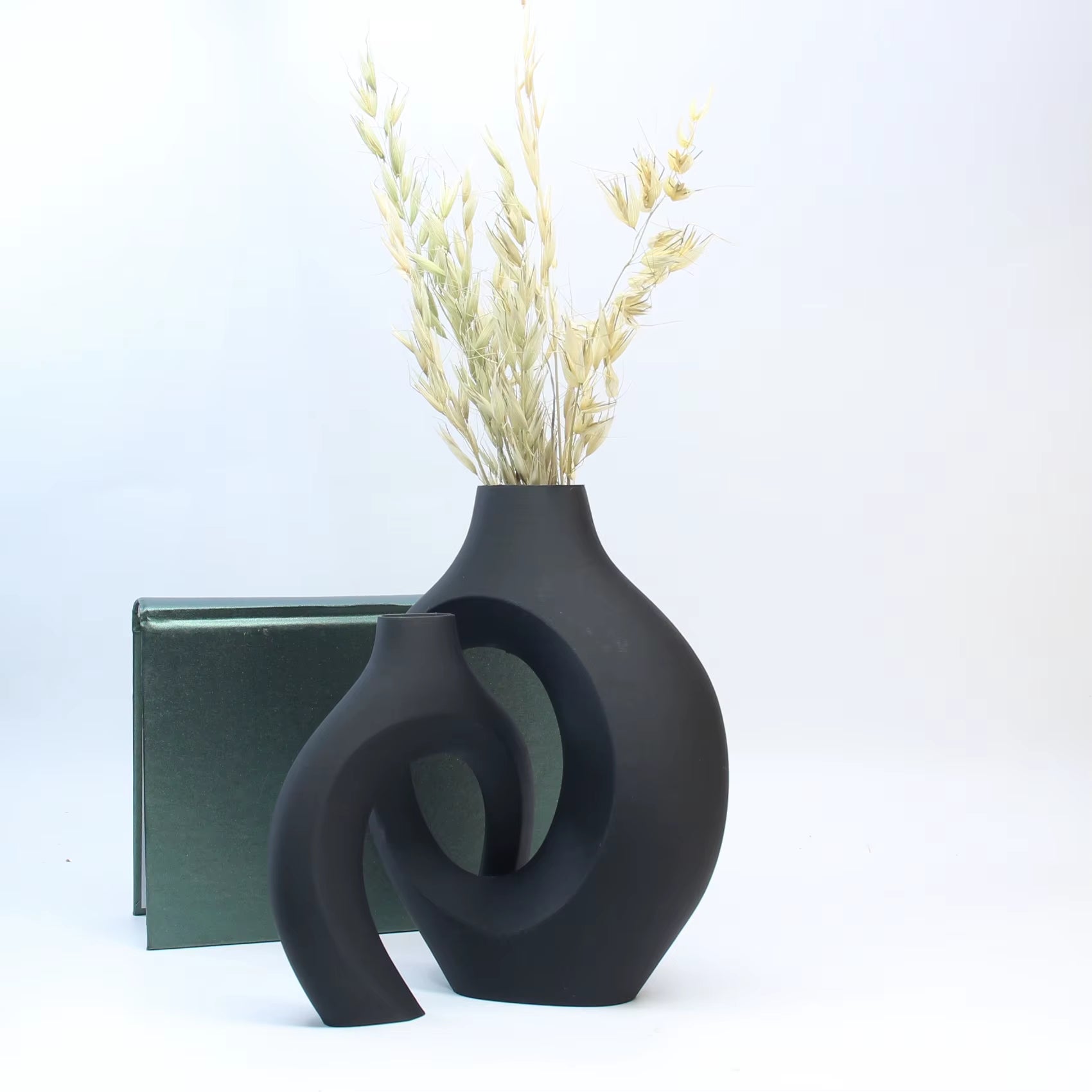 Jarrón Decorativo para Oficina y Gabinete de Entrada con flores secas y fondo de libro verde.